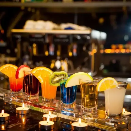 side-view-cocktail-shots-with-slice-lemon-kiwi-slice-candles-bar (1) (1) (1)